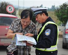 标题：指路
作者：云南省公安厅交警总队高速公路交巡警支队何廷睿
内容：图中民警叫孙毅，现年55岁，1976年参加工作，先后担任过交警大队长、事故科副科长、秩序科副科长等职务，孙毅同志39年从警不改初衷，爱岗敬业，数十年如一日从事道路交通管理工作。在工作中细心、耐心，执法严格，服务热情。该照片拍于春运期间，孙毅同志值守在昆曲高速公路，热心为前来云南旅游的群众指路。”