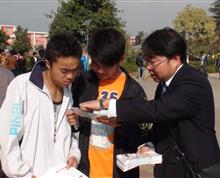 云南省农村信用社员工向入学新生介绍金碧校园卡的功能和服务”