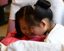 在昆明市图书馆主办、《云南教育幼儿教育》协办的“2015为爱伴读——21天亲子阅读”颁奖活动上，等待的时间里，两个爱看书的小姑娘争分夺秒地阅读。当孩子爱上阅读，我们的中国梦便会更加精彩。”
