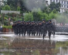 题目：涉水而行。介绍：9月10日下午14时，晋宁县反恐演练在晋城镇古滇文化广场进行，云南省第一女子监狱微冲方队在广场中央列队完毕，严阵以待，初秋天气时晴时雨，当天下午天气骤变，乌云压顶、电闪雷鸣，昏暗的天色反而更加凸显女一监方队臂章上五星红旗的鲜艳。暴雨突降，广场中央瞬时积水十几厘米。演练正式开始时，暴雨渐小，积水没过脚踝、雨水湿透全身，女一监微冲方队警容严整，巍然屹立在淅沥的雨中，展现了女一监优良的纪律作风。作者：袁雪梅，联系电话：13577086751”