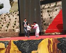 小朋友为“小人国”的表演者献花。爱和平等是社会和谐的基石。”