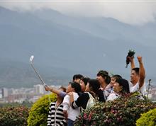 在大理洱海边，脸上溢满幸福的游客自拍，凸显出了中国“富强、文明、和谐”的场景。”